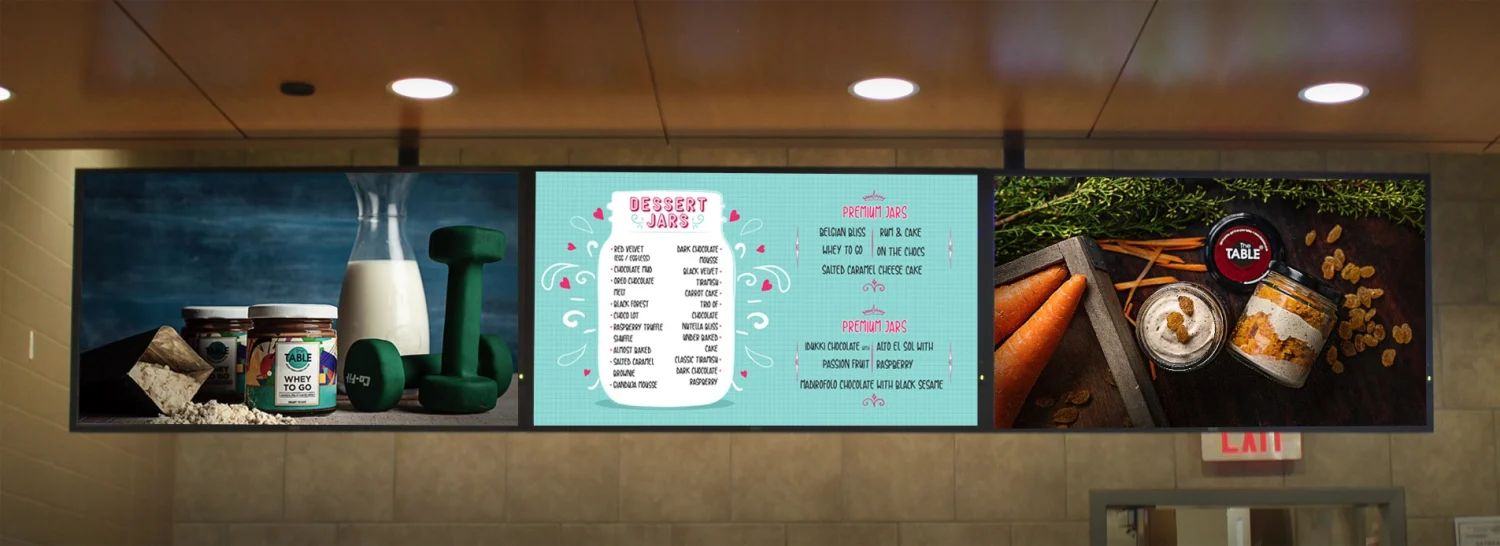 Three ceiling-mounted screens running an image slideshow of products, a dessert menu and branding